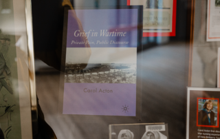 A display case at St. Jerome’s University features the book "Grief in Wartime: Private Pain, Public Discourse" by Carol Acton. The cover, surrounded by framed pictures, depicts a black-and-white wartime scene—a poignant nod to Remembrance Day and the sacrifices of wartime nurses.