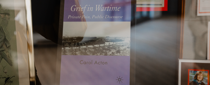 A display case at St. Jerome’s University features the book "Grief in Wartime: Private Pain, Public Discourse" by Carol Acton. The cover, surrounded by framed pictures, depicts a black-and-white wartime scene—a poignant nod to Remembrance Day and the sacrifices of wartime nurses.