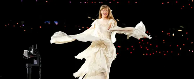 A performer in a flowing white dress twirls on stage, surrounded by dim lights and a backdrop of glowing audience lights, creating a dynamic and enchanting atmosphere. The event echoes the spirit of Canada's vibrant arts scene, drawing attention to ticket resale regulations.