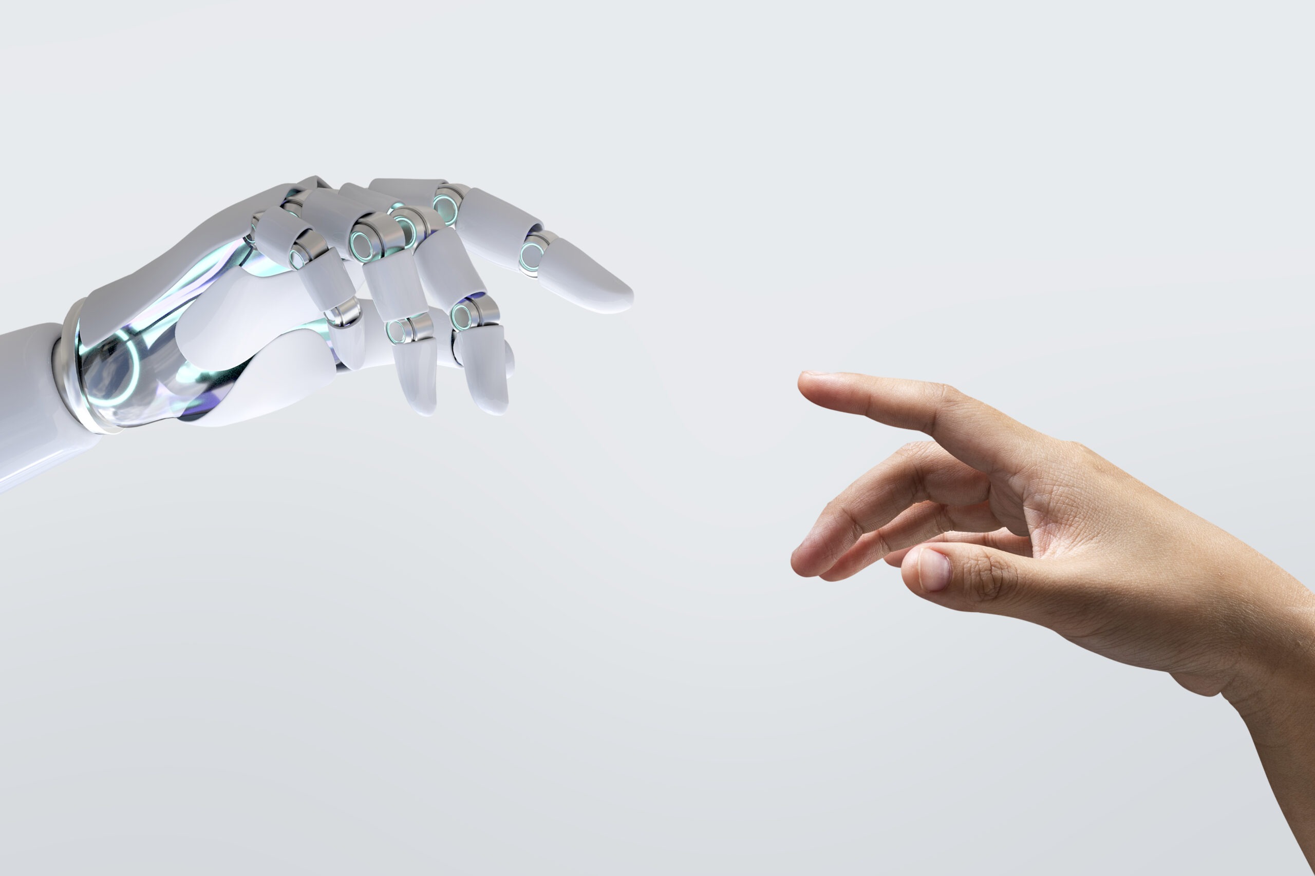 A robotic hand and a human hand reach toward each other against a light background, their fingertips nearly touching, symbolizing the evolving connection between technology and humanity in an era of AI detection.