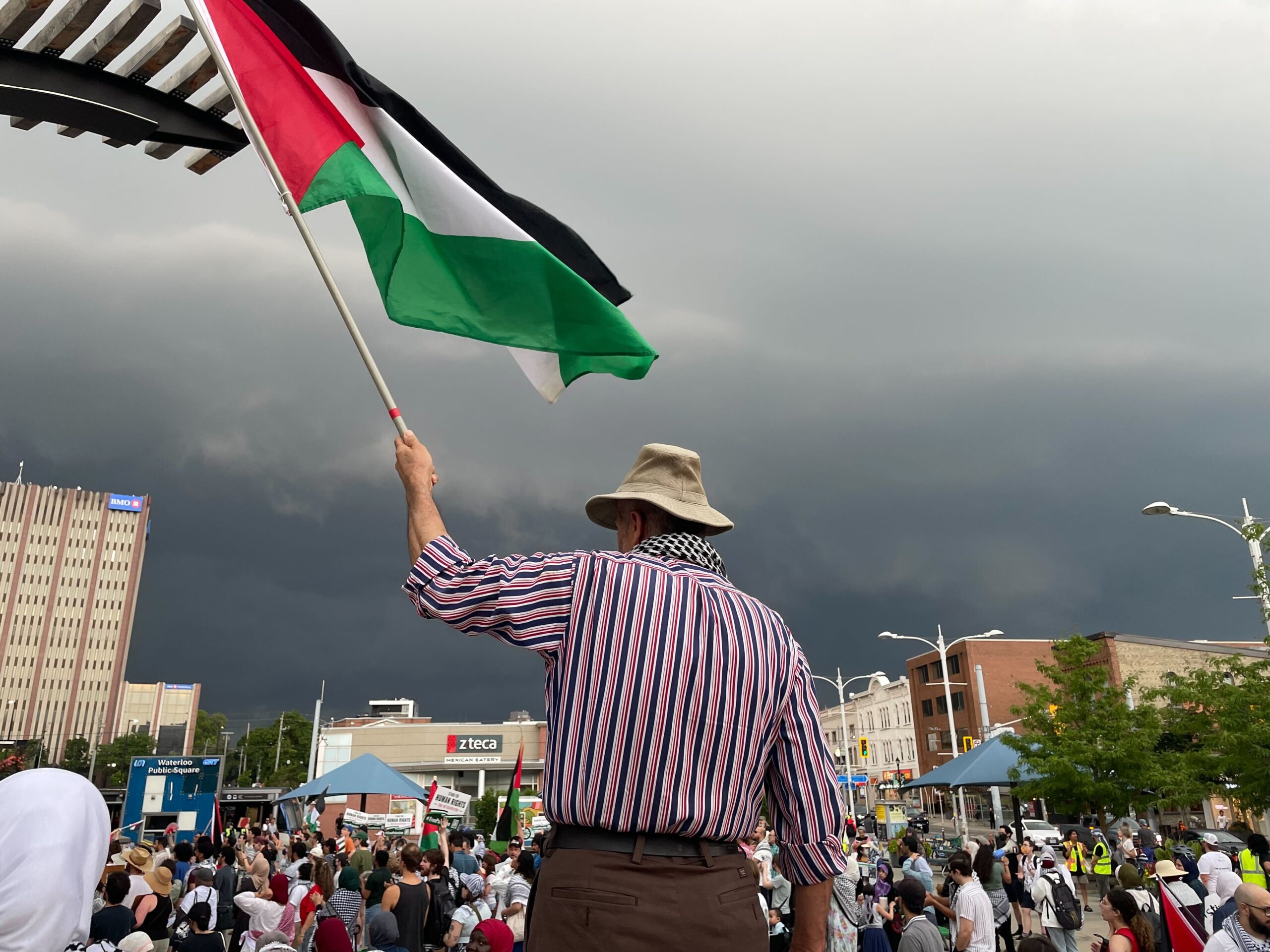 A protestor holding up a Palestinian flag in Waterloo Town Square on July 24. (Photo credit: Brendon Poste)