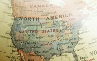 A close-up of a globe showing North America, including Canada, the United States, Mexico, and parts of Central America and the Caribbean. Country and city names are clearly visible, offering insight into the US Canada political climate.